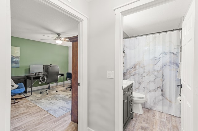 bathroom featuring ceiling fan, hardwood / wood-style floors, vanity, and toilet