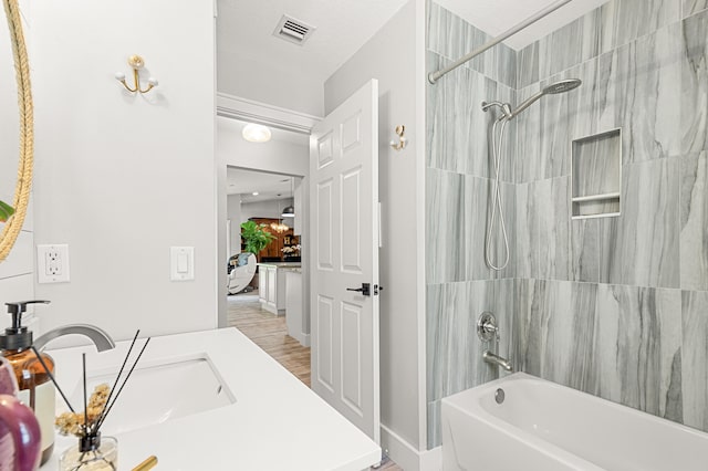 bathroom featuring bathing tub / shower combination, hardwood / wood-style floors, vanity, and a textured ceiling