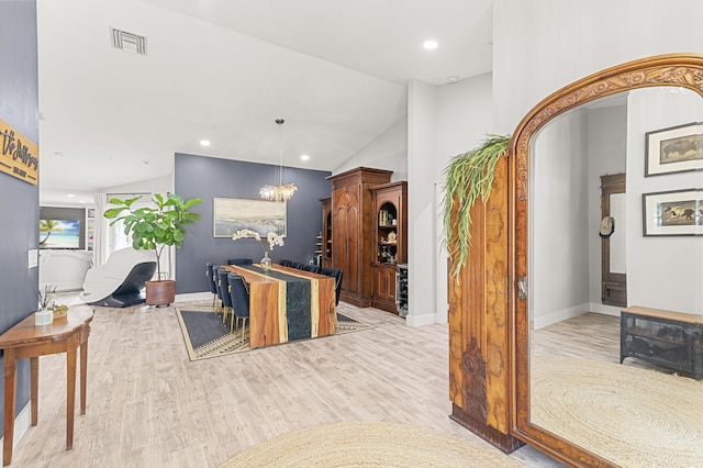 interior space with pendant lighting, an inviting chandelier, lofted ceiling, and light hardwood / wood-style flooring