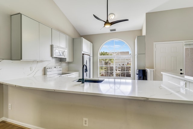 kitchen with electric range, white cabinetry, light stone countertops, and kitchen peninsula