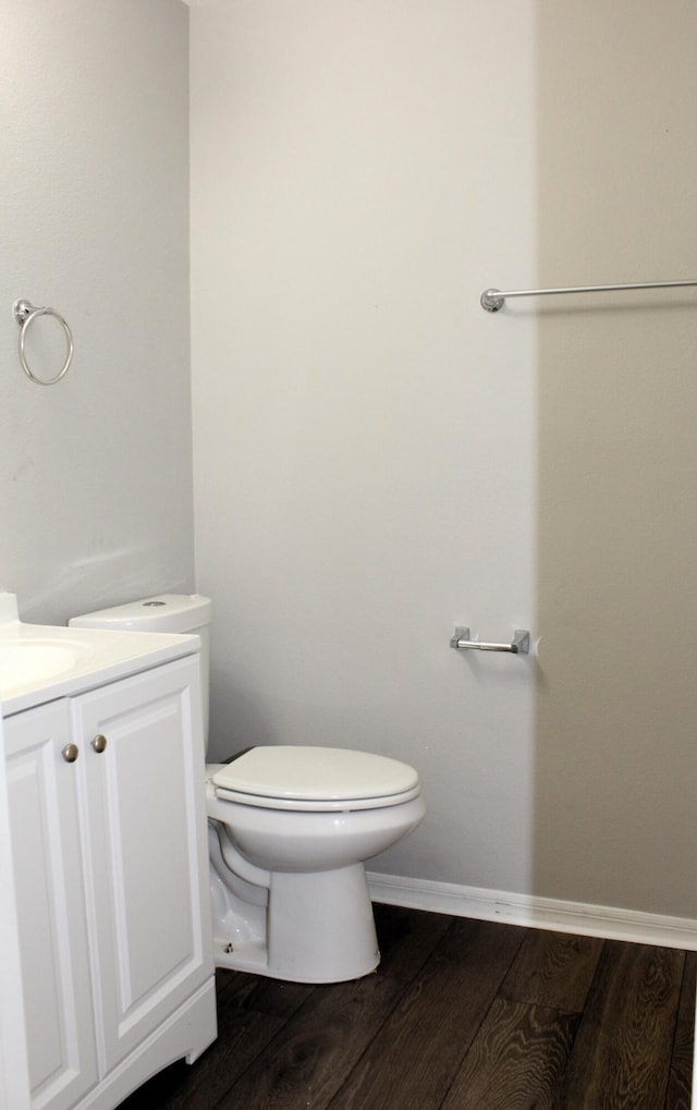 bathroom with baseboards, vanity, toilet, and wood finished floors