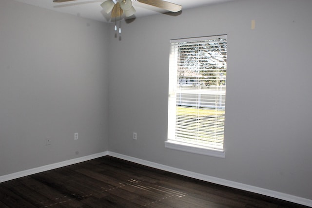 unfurnished room featuring ceiling fan, dark wood-type flooring, and baseboards