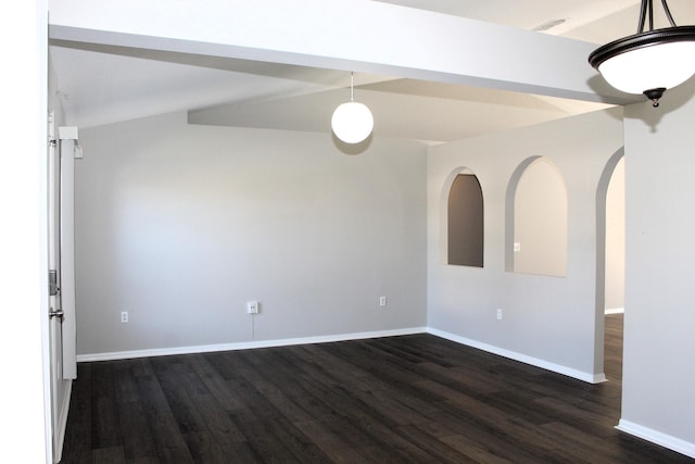 empty room with dark wood-type flooring, arched walkways, and baseboards