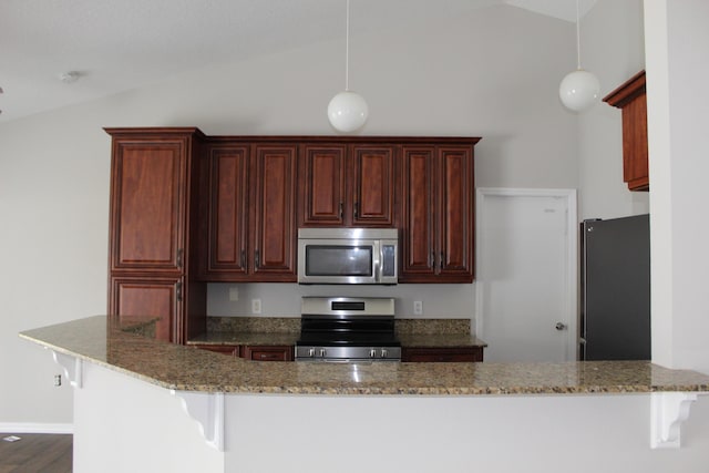 kitchen featuring lofted ceiling, light stone counters, appliances with stainless steel finishes, and a breakfast bar