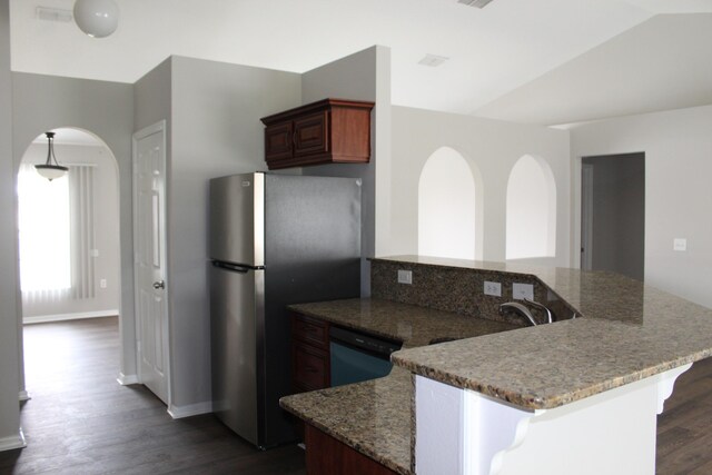 kitchen with lofted ceiling, freestanding refrigerator, light stone countertops, a peninsula, and dishwashing machine