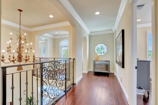 hall with crown molding, dark hardwood / wood-style flooring, and a notable chandelier