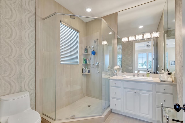 bathroom featuring a wealth of natural light, ceiling fan, vanity, and toilet