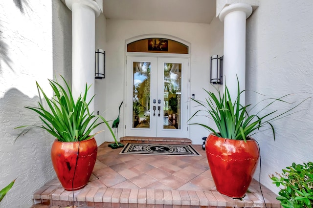 view of exterior entry featuring stucco siding and french doors