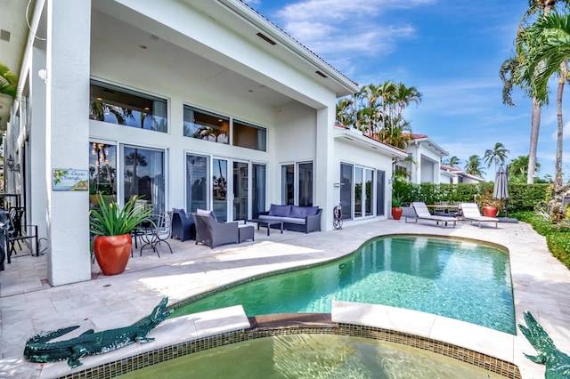 rear view of house with a patio area, an outdoor living space, and a pool with hot tub