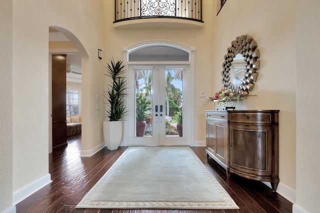 entryway with a high ceiling, baseboards, dark wood-style flooring, and french doors