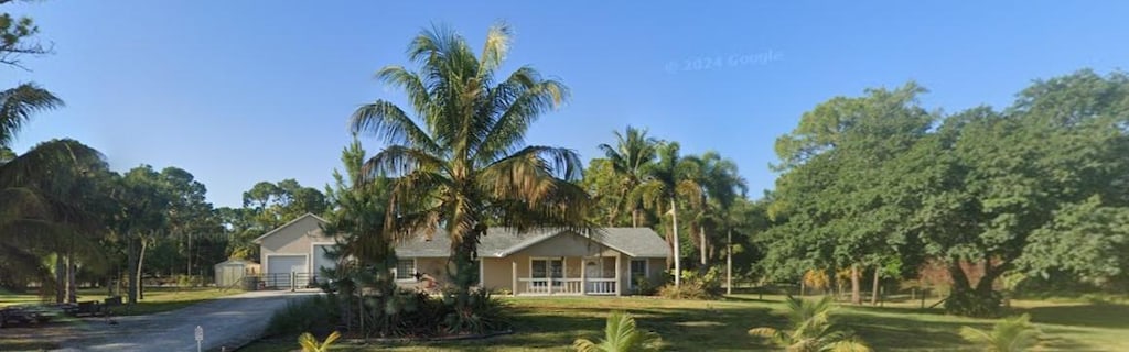 view of front facade with covered porch, a garage, and a front yard