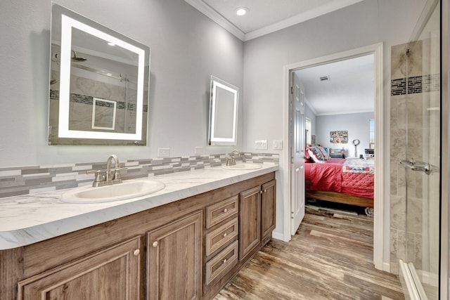 bathroom with crown molding, wood-type flooring, an enclosed shower, decorative backsplash, and vanity