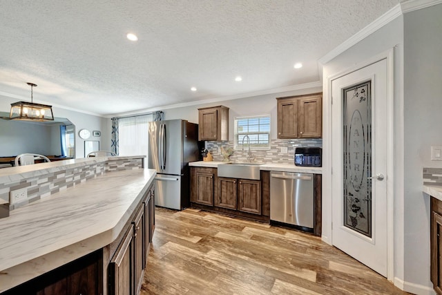 kitchen with decorative backsplash, stainless steel appliances, a healthy amount of sunlight, and sink