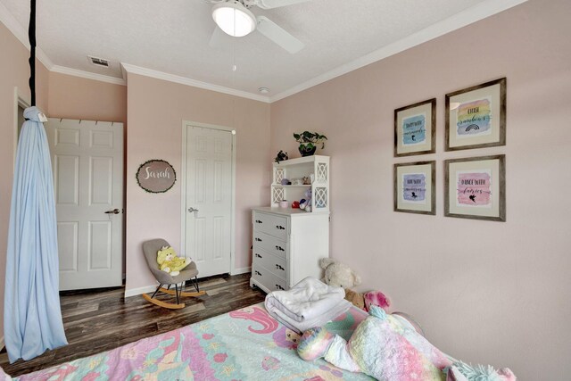 bedroom featuring dark hardwood / wood-style floors, ceiling fan, and crown molding