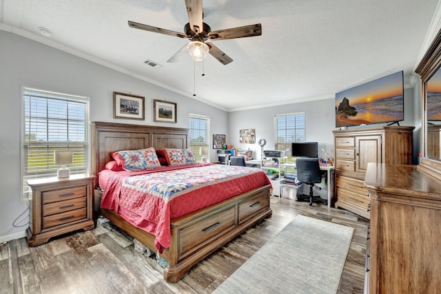 bedroom featuring multiple windows, hardwood / wood-style flooring, ceiling fan, and lofted ceiling