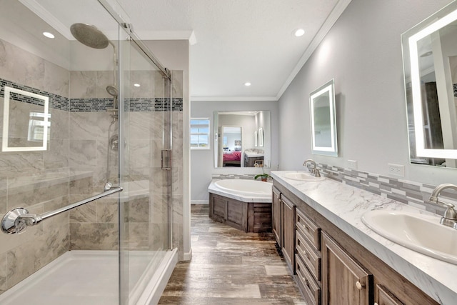 bathroom with crown molding, wood-type flooring, shower with separate bathtub, decorative backsplash, and vanity