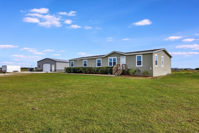 view of front of home with a garage, an outdoor structure, and a front yard