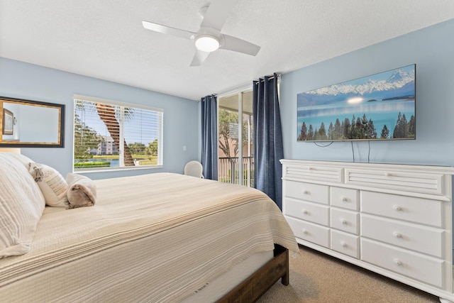 carpeted bedroom featuring a textured ceiling and ceiling fan