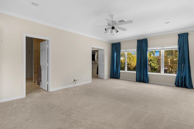 empty room featuring crown molding, ceiling fan, and light carpet