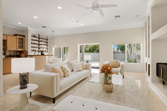 kitchen featuring ceiling fan, light brown cabinets, stainless steel appliances, crown molding, and decorative light fixtures