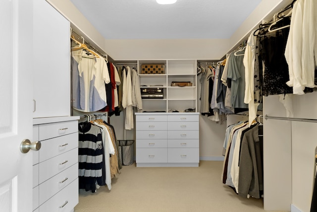 walk in closet featuring light colored carpet