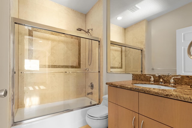 full bathroom with vanity, shower / bath combination with glass door, and toilet