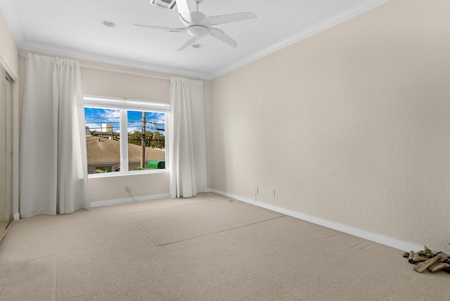 spare room featuring ceiling fan, ornamental molding, and light carpet