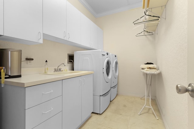 laundry area with cabinets, ornamental molding, sink, and washing machine and dryer