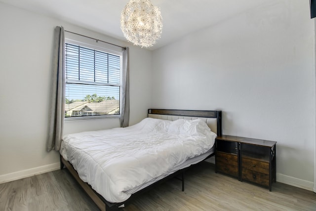 bedroom featuring a chandelier and wood-type flooring