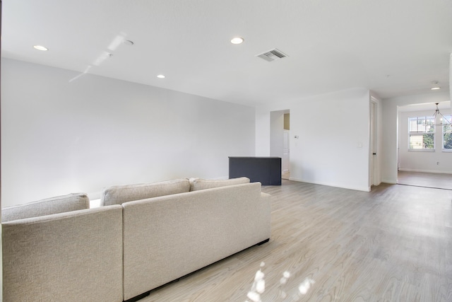 unfurnished living room featuring a chandelier and hardwood / wood-style flooring