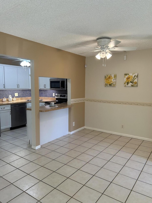 kitchen with light tile patterned floors, ceiling fan, white cabinetry, backsplash, and stainless steel appliances