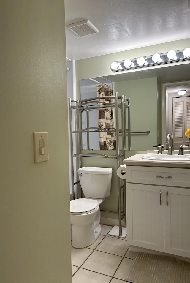 half bath with tile patterned floors, visible vents, toilet, and vanity