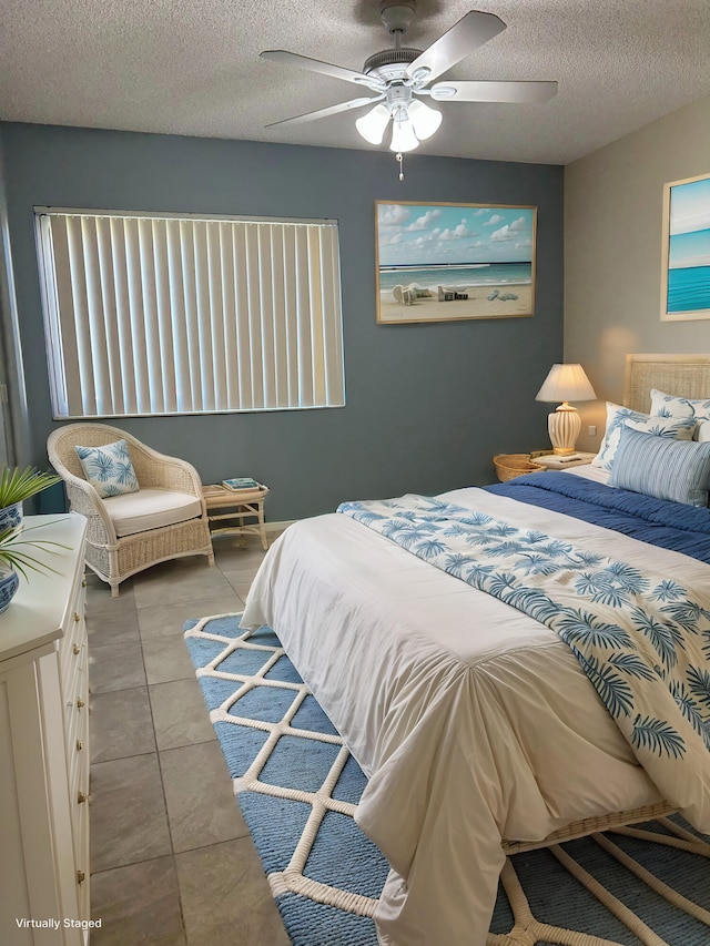 tiled bedroom with a textured ceiling and a ceiling fan