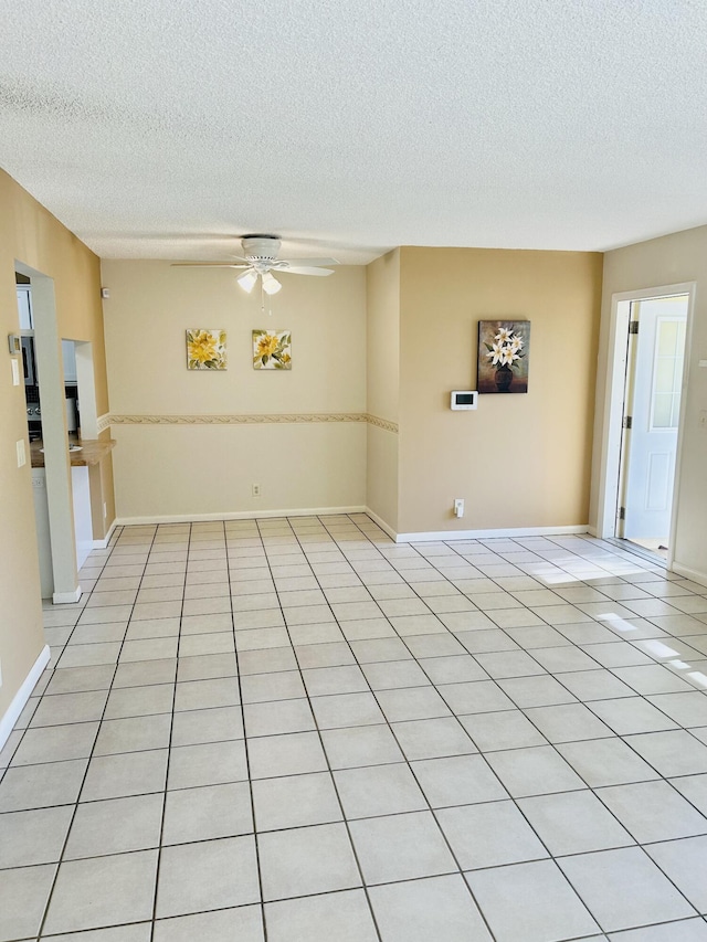 unfurnished room with light tile patterned flooring, ceiling fan, and a textured ceiling