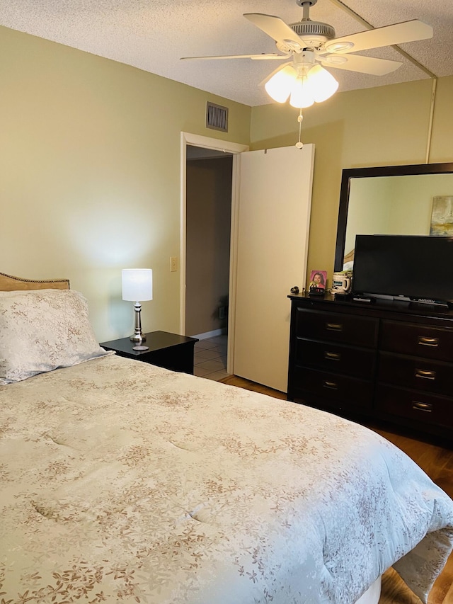 bedroom featuring ceiling fan and a textured ceiling