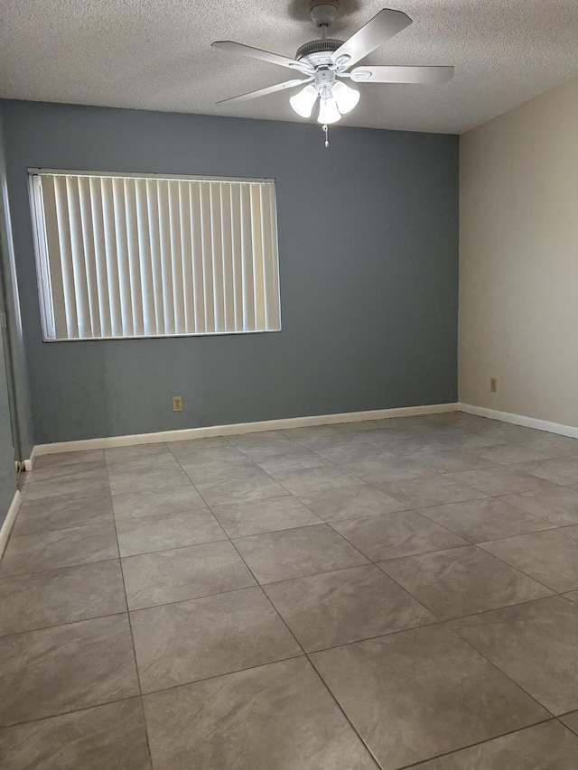 tiled spare room with ceiling fan and a textured ceiling