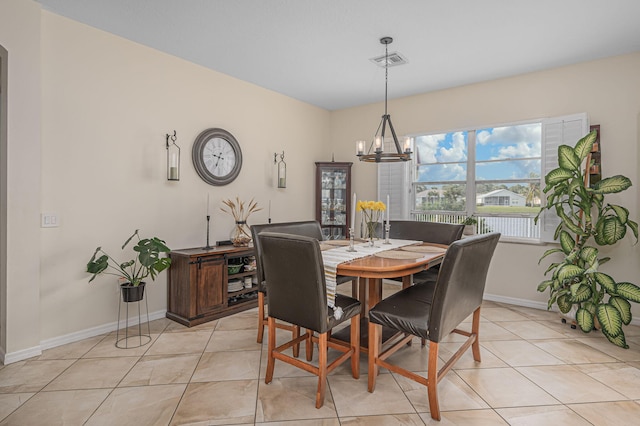 tiled dining room with a chandelier