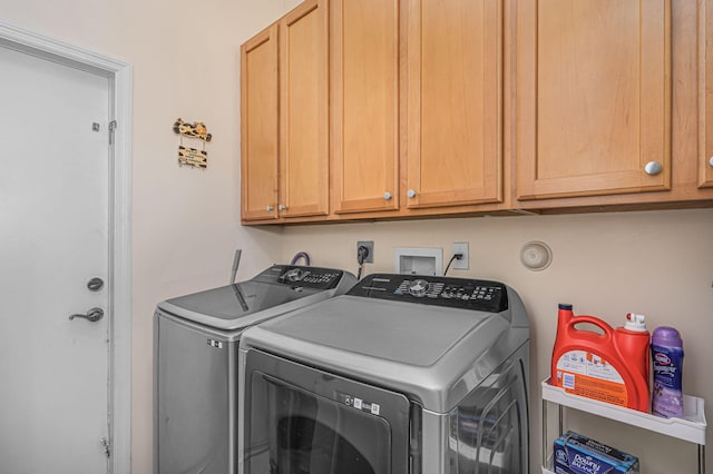 laundry area with washer and dryer and cabinets