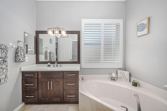 bathroom with tile patterned floors, tiled tub, and vanity