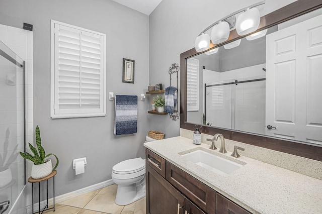 bathroom with tile patterned floors, vanity, a shower with shower door, and toilet