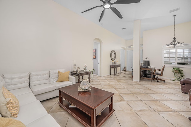 living room featuring ceiling fan with notable chandelier, light tile patterned floors, and vaulted ceiling