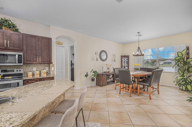 tiled dining area featuring a chandelier