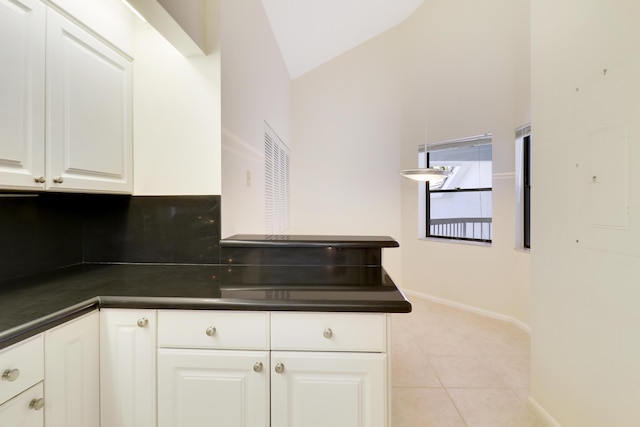 kitchen with white cabinets, lofted ceiling, and light tile patterned floors