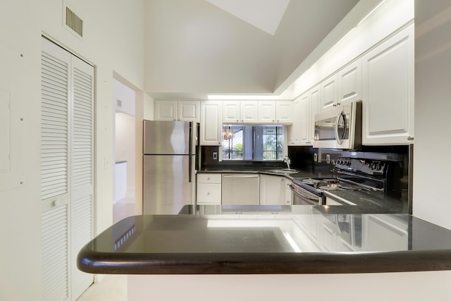 kitchen with kitchen peninsula, appliances with stainless steel finishes, sink, high vaulted ceiling, and white cabinets