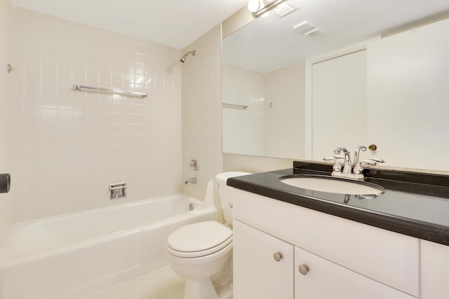 full bathroom featuring tile patterned floors, vanity, tiled shower / bath combo, and toilet