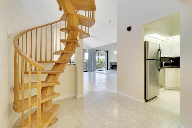 stairs featuring tile patterned floors and vaulted ceiling