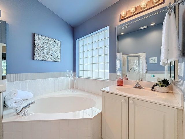 bathroom with a wealth of natural light, vanity, and shower with separate bathtub