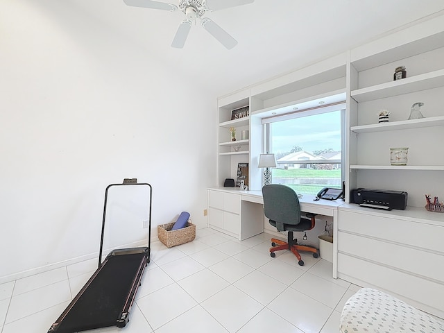 office space with built in shelves, ceiling fan, built in desk, and light tile patterned floors