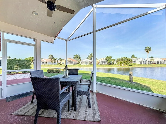 sunroom / solarium featuring a water view, ceiling fan, and lofted ceiling