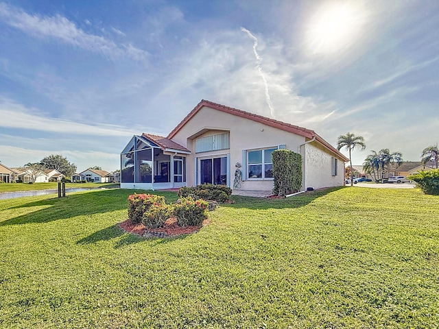 view of front of property with a sunroom and a front yard